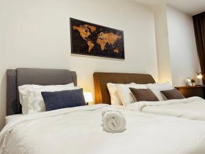 吉隆坡Arcoris Mont Kiara 1~6 Pax Contemporary Living Netflix的卧室内的两张床,墙上有地图