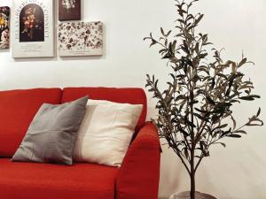 吉隆坡Arcoris Mont Kiara 1~6 Pax Contemporary Living Netflix的红色的沙发,带有枕头和一棵树