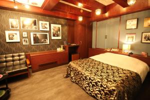 东京Hotel OLDSWING Adult Only的一间卧室配有一张床和一把椅子