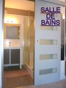 巴里吉斯APPARTEMENT CLAIR ET MODERNE AU CALME的带有白门的卖物标志的浴室