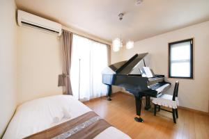 东京押上ハウス的一间卧室配有钢琴和一张床