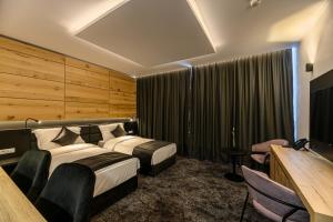 圣格奥尔基B THE HOTEL的酒店客房设有两张床和电视。