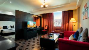 麦纳麦Arman Hotel Juffair Mall的客厅配有红色沙发和电视