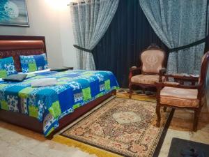 卡拉奇Seaview Lodge Guest House的一间卧室配有一张床和一把椅子