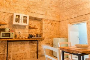 切列梅萨皮卡La Casedda - Apartment & Hydromassage的厨房配有木桌和桌椅