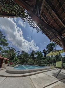 日惹VILLA OPA DOEL YOGYAKARTA的享有带遮阳伞的游泳池的景色