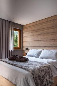 法尔西德Suite Mia的一间卧室设有一张带木墙的大床