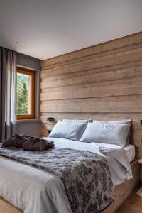 法尔西德Suite Mia的一间卧室设有一张带木墙的大床