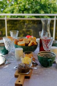 Argenton-ChâteauLes chambres de la vallée的一张桌子,上面放着一碗面包和酒杯