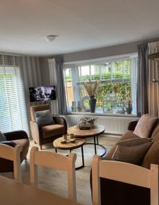 洪德洛Luxe Chalet met prachtig terras op de Veluwe , veel privacy的客厅配有沙发、椅子和桌子