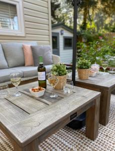 洪德洛Luxe Chalet met prachtig terras op de Veluwe , veel privacy的一张木桌,配有一瓶葡萄酒和玻璃杯