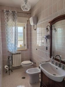 斯卡莱阿Rosy house的浴室配有盥洗盆、卫生间和盥洗盆。