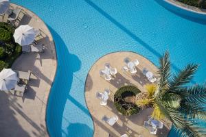 AlaminosROBINSON Cyprus的享有带椅子和遮阳伞的游泳池的上方景致