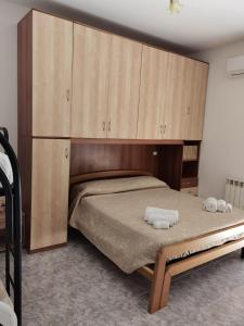 斯卡莱阿Rosy house的一间卧室配有一张带木制橱柜的大床