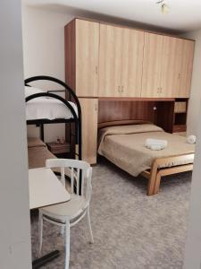 斯卡莱阿Rosy house的一间卧室配有一张床、一把椅子和一张桌子