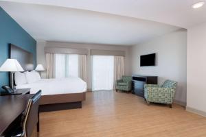 大洋城海洋城拉金塔旅馆及套房酒店的酒店客房,配有一张床、一张桌子和椅子