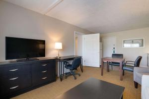 奥本Quality Inn & Suites的客厅配有平面电视和书桌。