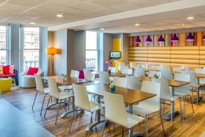 布莱克浦Forshaws Hotel - Blackpool的用餐室配有桌子和白色椅子