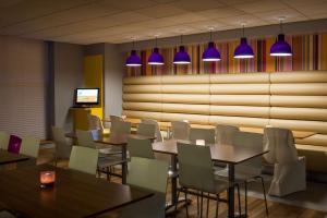布莱克浦Forshaws Hotel - Blackpool的餐厅设有桌椅和紫色灯