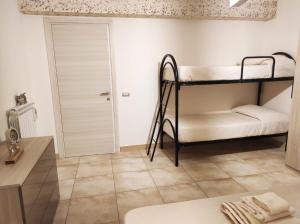 孔图尔西Dadilò - Casa Vacanza & Bed and breakfast的客房设有两张双层床和一张桌子。