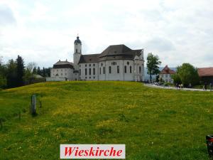 EurasburgFür Ihren Urlaub 2024 Fremdenzimmer-Appartement Eurasburg im Loisachtal - Tölzer Land的绿色田野顶部的大建筑