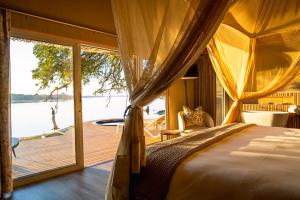 维多利亚瀑布维多利亚瀑布河山林小屋的一间卧室配有一张床,享有水景