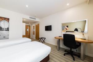 温彻斯特假日温切斯特酒店的酒店客房配有书桌和床。