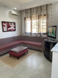 乌姆苏克Zahra 1的客厅配有红色沙发和电视