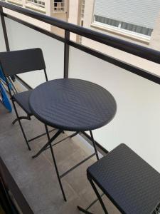 坎布里尔斯Apartments Gran VP的阳台配有一张黑桌子和一把椅子