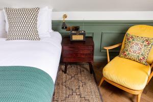 伦敦The Bull & Last的一间卧室配有一张床、一张桌子和一把椅子
