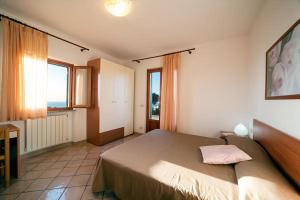 马尔恰纳Da Angiolina的一间卧室设有一张大床和两个窗户。