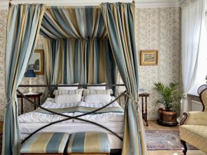 Floda纳斯劳特乡村民宿的一间卧室配有一张带蓝色窗帘的天蓬床