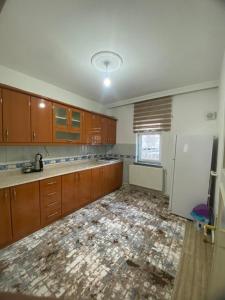 内夫谢希尔Budak Home的空厨房配有木制橱柜和白色冰箱