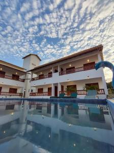 日若卡-迪热里科阿科阿拉Pousada Brisas的大楼前设有游泳池的酒店