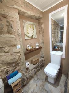 MazaricosA Cuadriña的浴室设有石墙内的白色卫生间