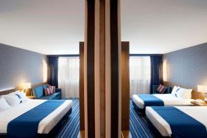 里斯本里斯本机场智选假日酒店的蓝色和白色的酒店客房内的两张床