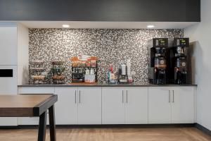 奥古斯塔Extended Stay America Premier Suites - Augusta的咖啡吧,配有白色橱柜和壁纸