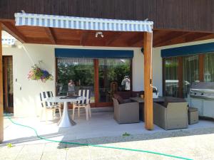 Les BoisChez l'Eveline的一个带遮阳篷和桌椅的庭院