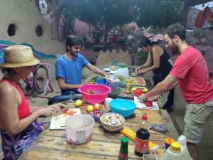 Kibbutz Lotan Eco-Campus的一群人站在桌子旁准备食物