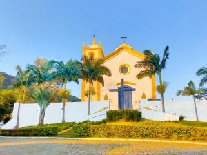 弗洛里亚诺波利斯Studios Altos da Igrejinha的前面有棕榈树的教堂