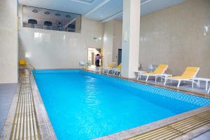 阿比让Hôtel FAMILLE MONDIALE的大楼内一个蓝色的大型游泳池