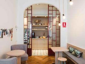 巴塞罗那卡萨马蒂尔达酒店的一间设有桌子和长凳的房间和一间厨房