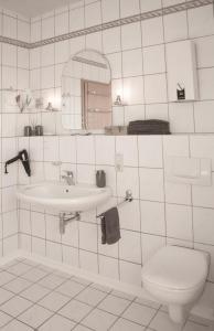 希莱斯海姆Gästehaus am Viehmarkt的白色瓷砖浴室设有水槽和卫生间