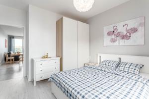 华沙Chill Apartments Ursus的白色卧室配有床、梳妆台和镜子