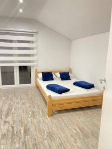 比哈奇Una Bihac 4的一间卧室配有一张带蓝色枕头的床和一扇窗户。