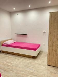 比哈奇Una Bihac 4的一间卧室配有一张带粉红色床单的大床