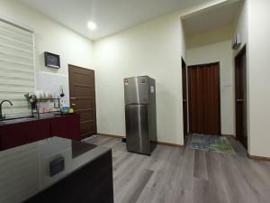 哥打巴鲁Fadli HOMESTAY的一间厨房,里面配有不锈钢冰箱