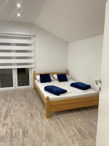 比哈奇Una Bihac 4的一间卧室配有一张带蓝色枕头的床和一扇窗户。