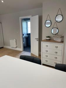The Woodside Snug, Eastwell, Vale of Belvoir的一间设有一张白色桌子和两面镜子的房间