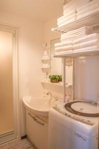 名古屋久Hisashi新栄店民泊的白色的浴室设有水槽和洗衣机。
